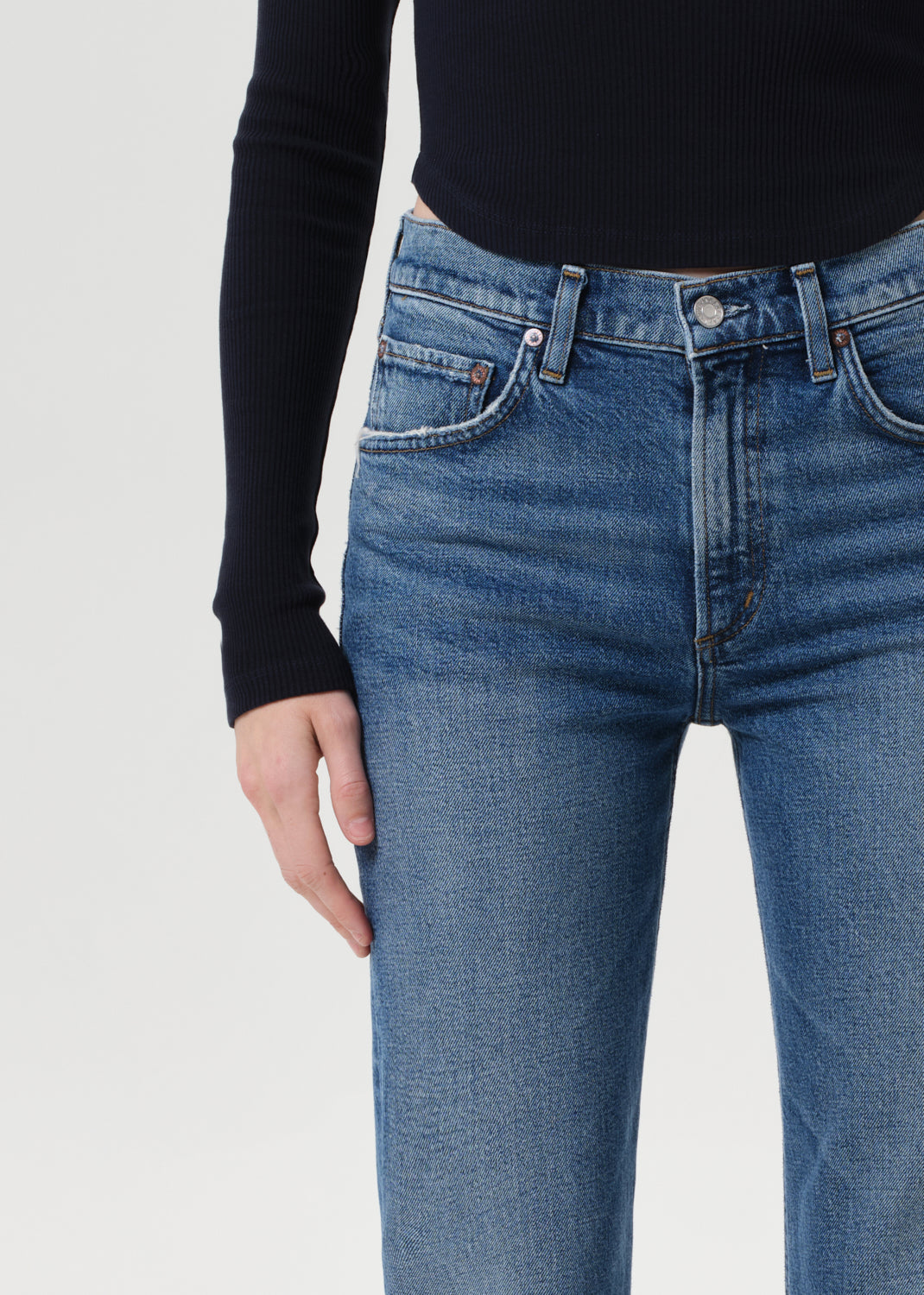 Blue jeans worn by a person on a white background