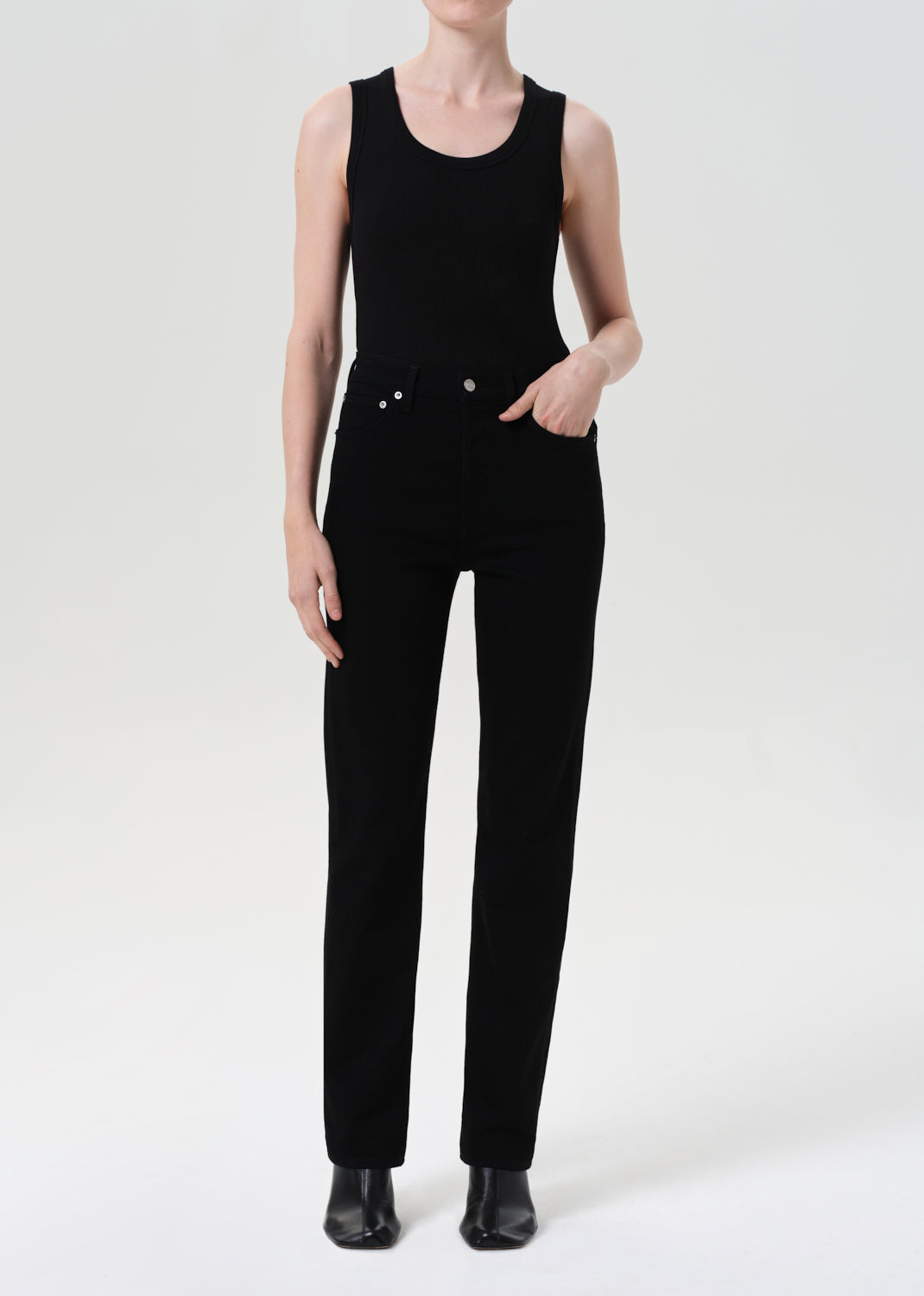 Person wearing a black sleeveless jumpsuit on a white background