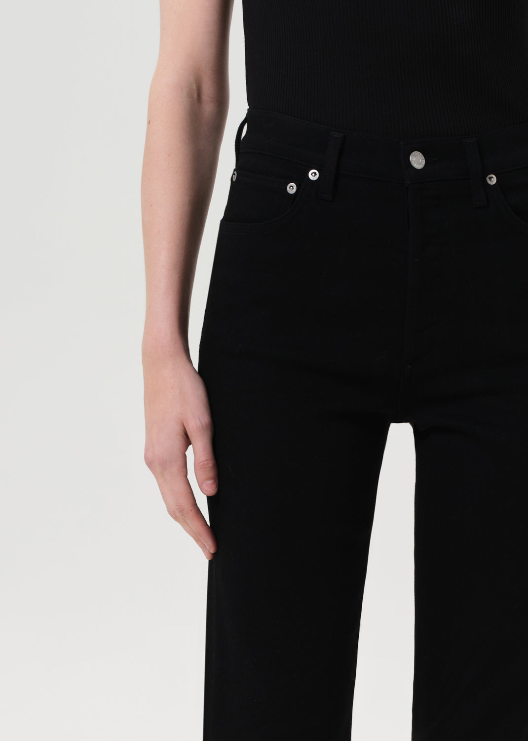 Black jeans worn by a person on a white background