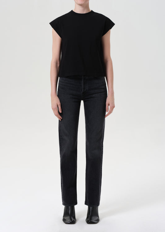 Person wearing a black sleeveless top and black pants on a white background