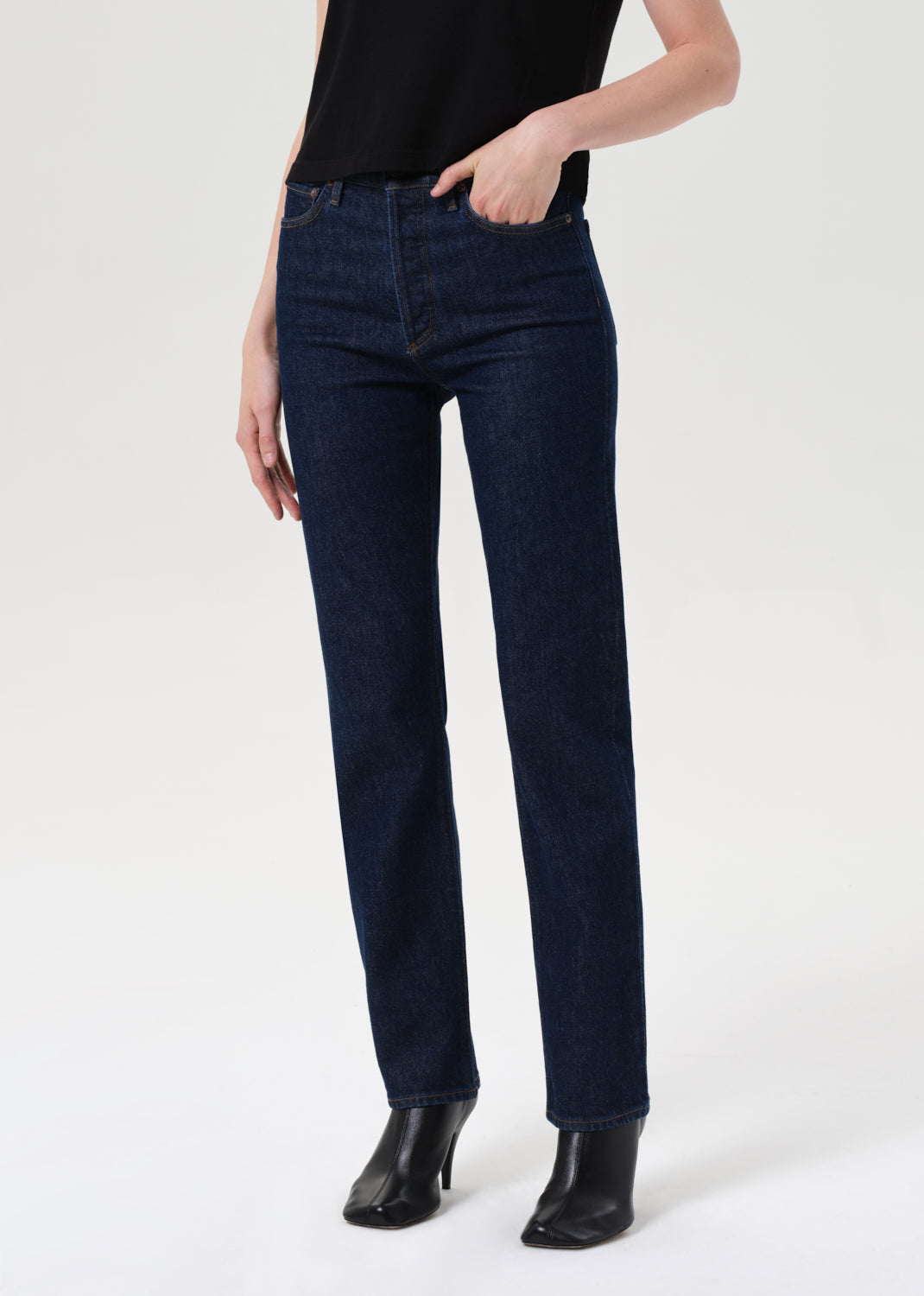 Person wearing dark blue jeans on a white background
