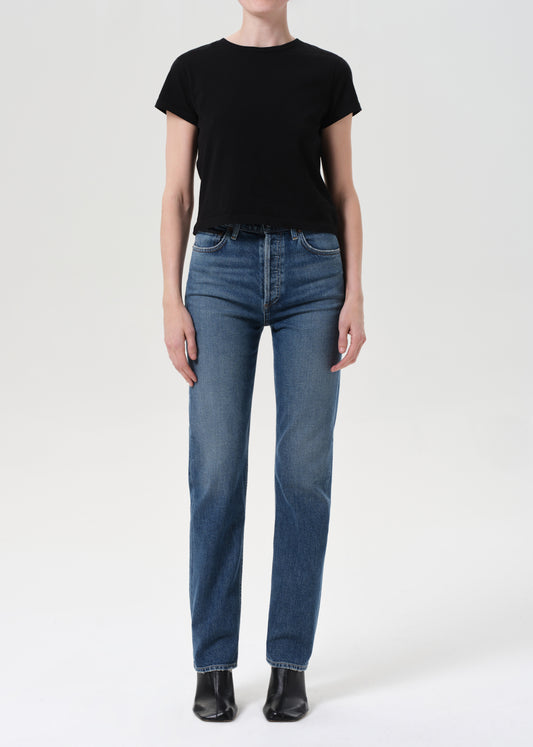 Person wearing a black t-shirt and blue jeans on a white background