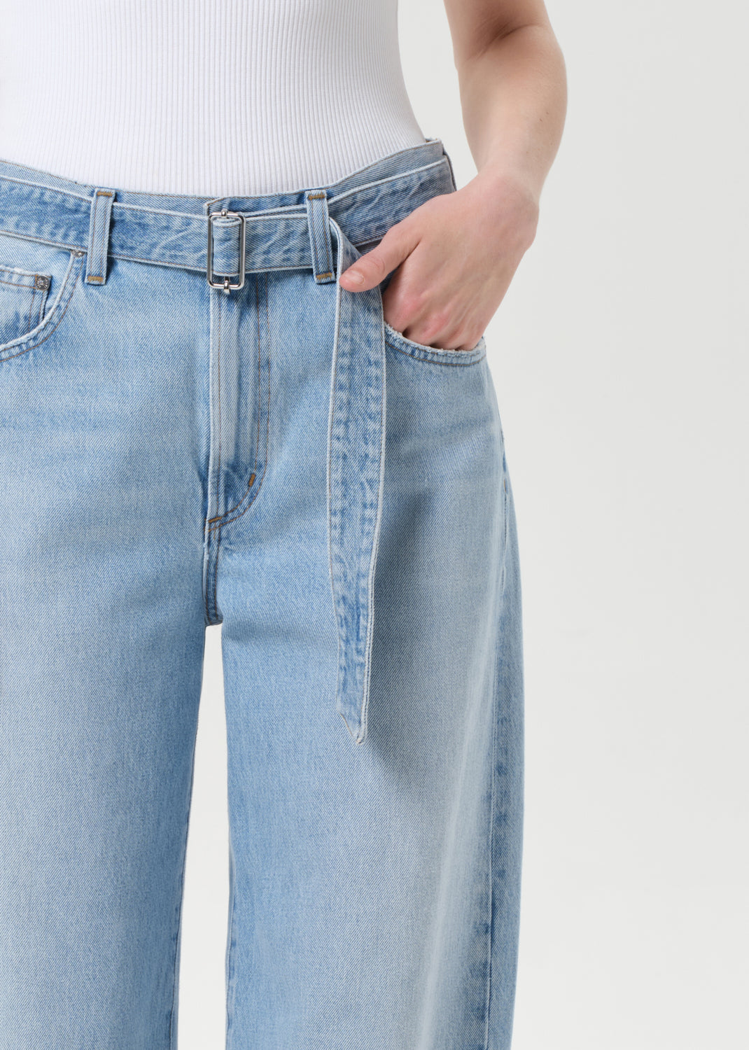 Light blue jeans worn by a person on a white background