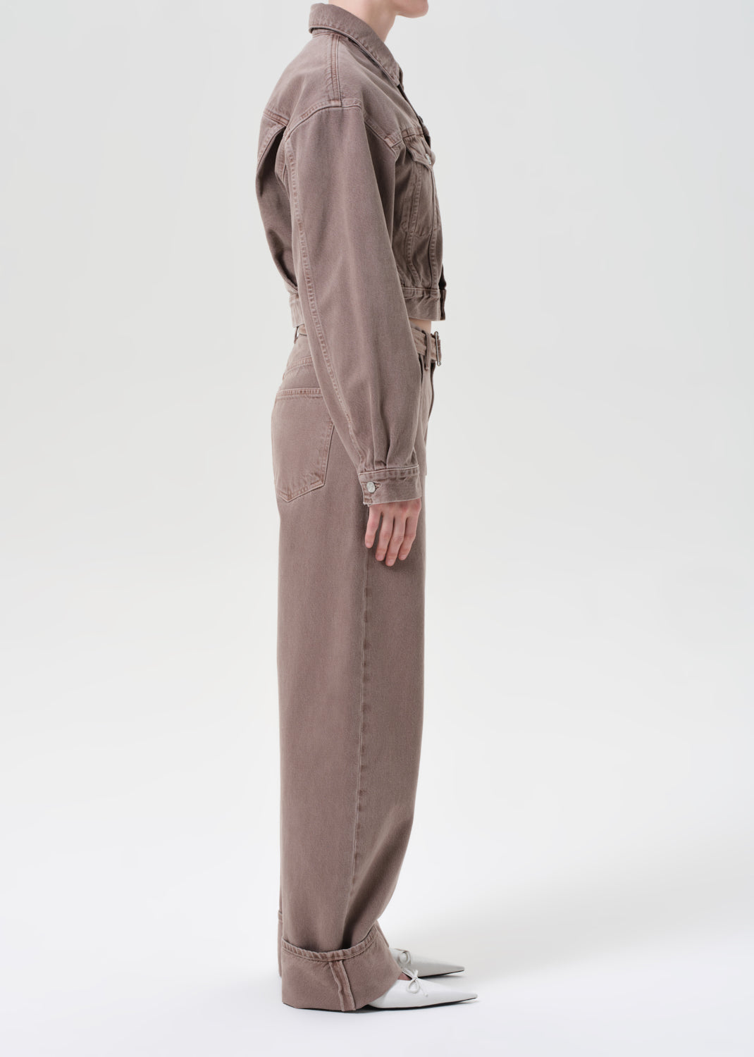Person wearing a brown jumpsuit on a white background
