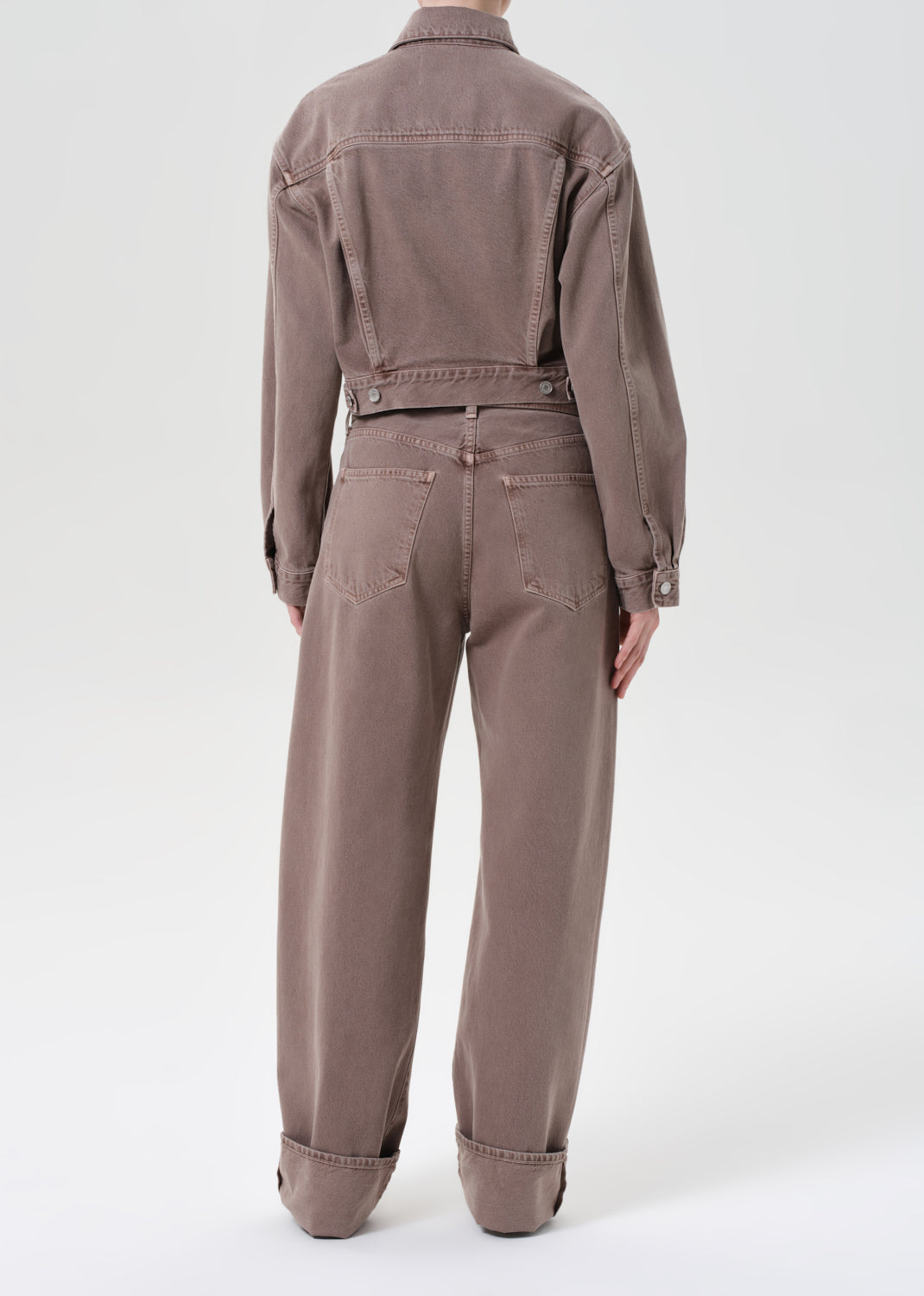 Brown jumpsuit worn by a person on a white background