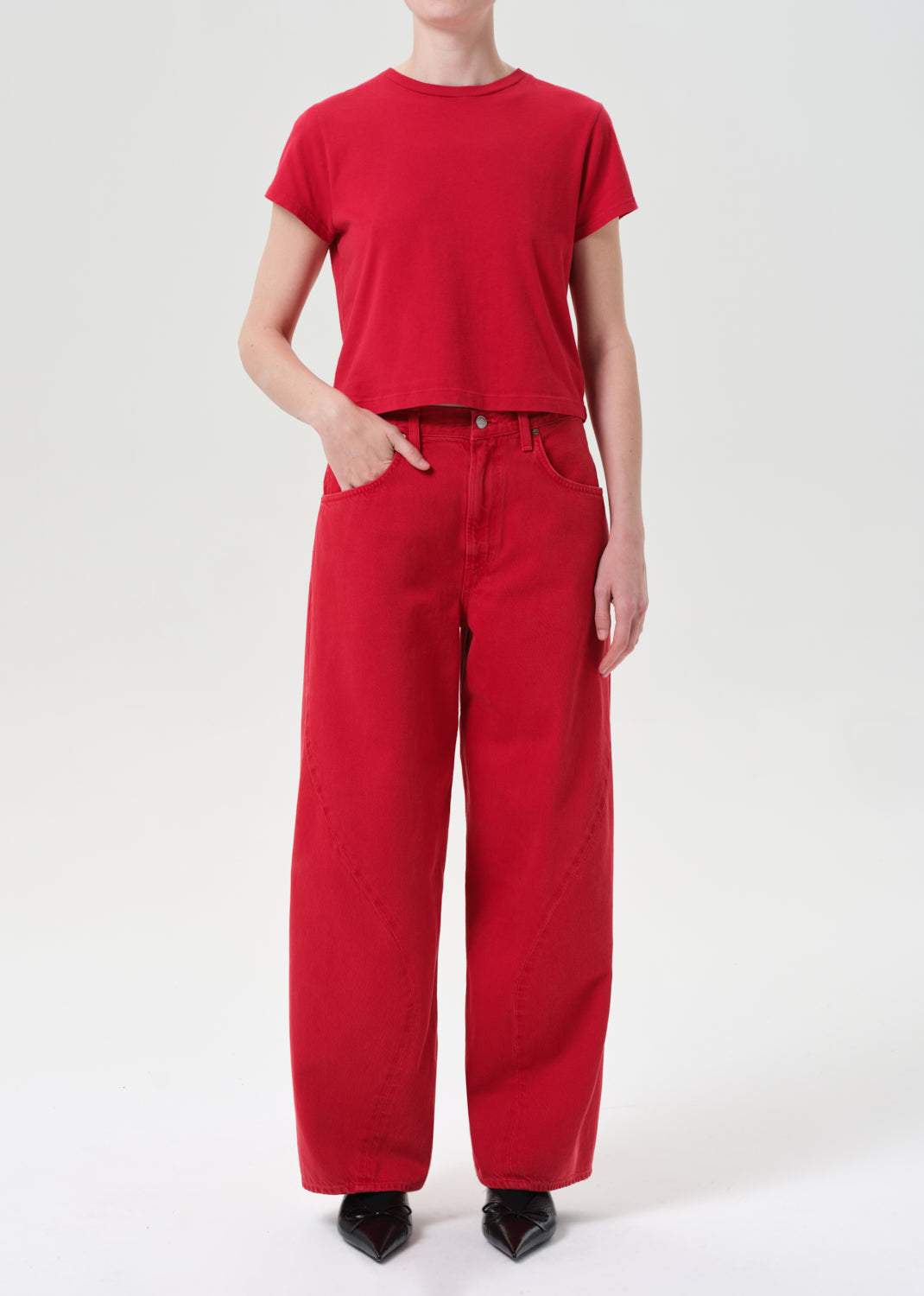 Person wearing a red t-shirt and red pants on a white background