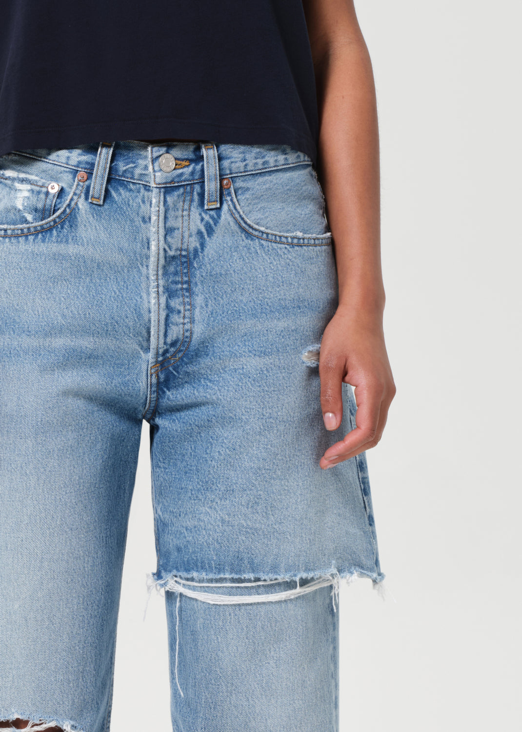 Light blue denim shorts worn by a person on a plain background