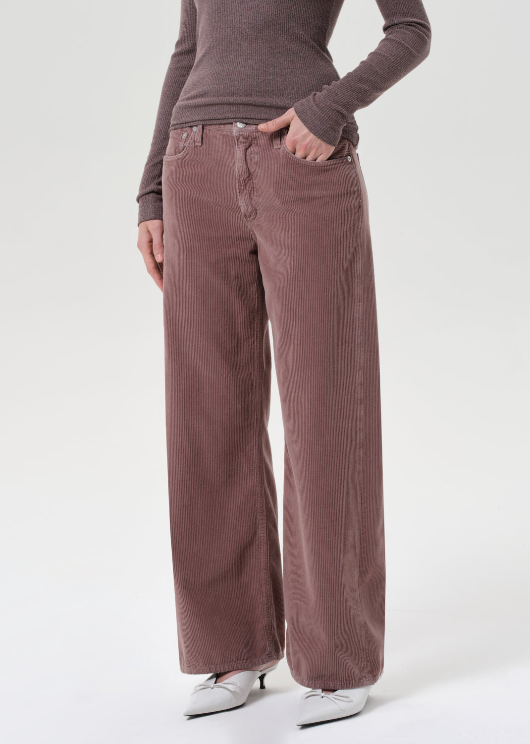 Person wearing brown wide-leg pants and a matching top on a white background