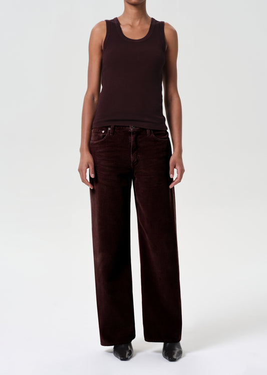 Person wearing a brown tank top and wide-leg pants on a white background