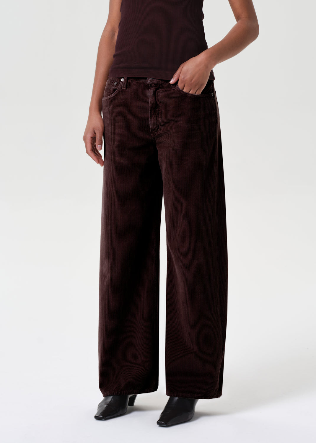 Person wearing brown wide-leg pants on a white background