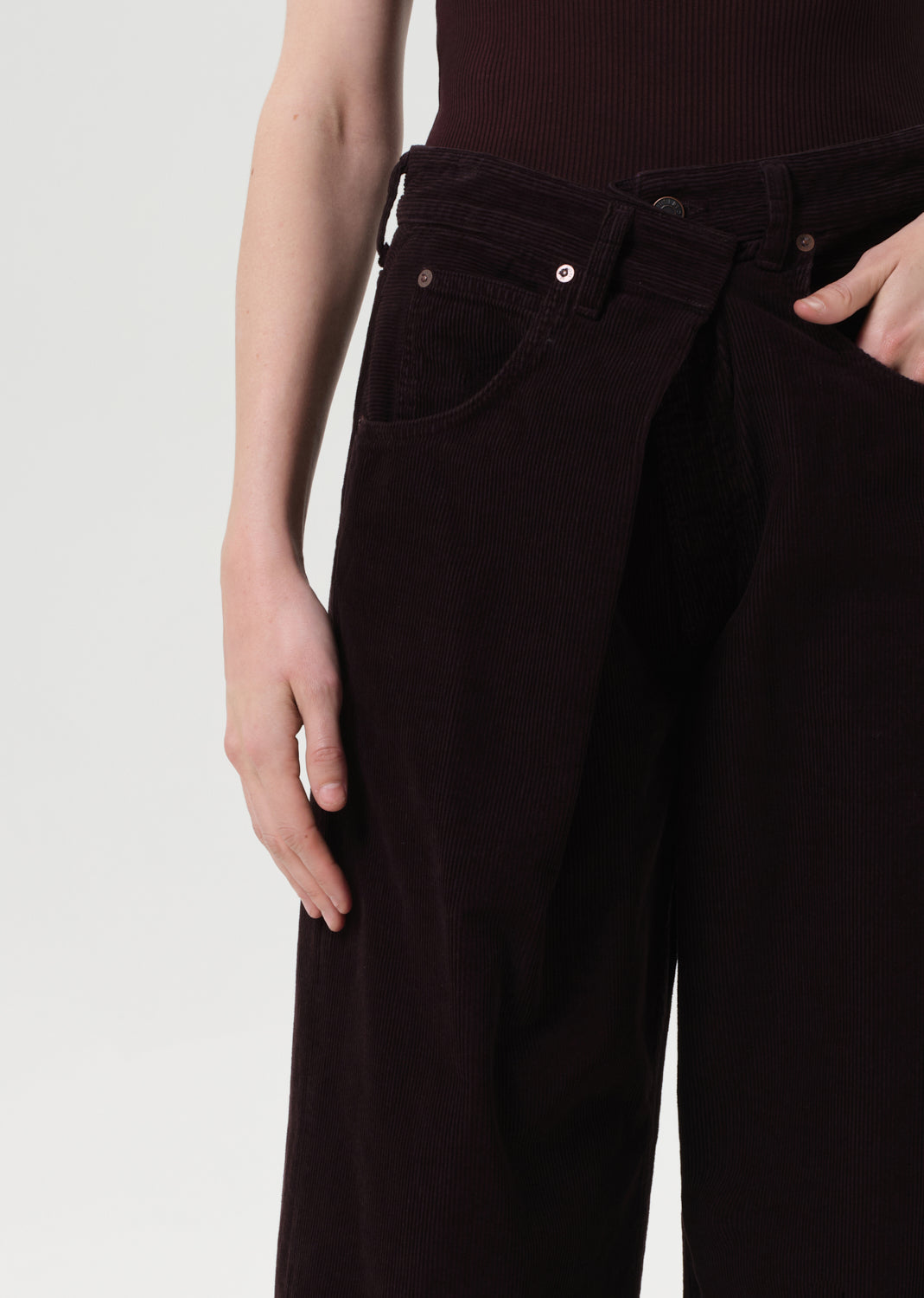 Dark brown pants worn by a person on a light gray background