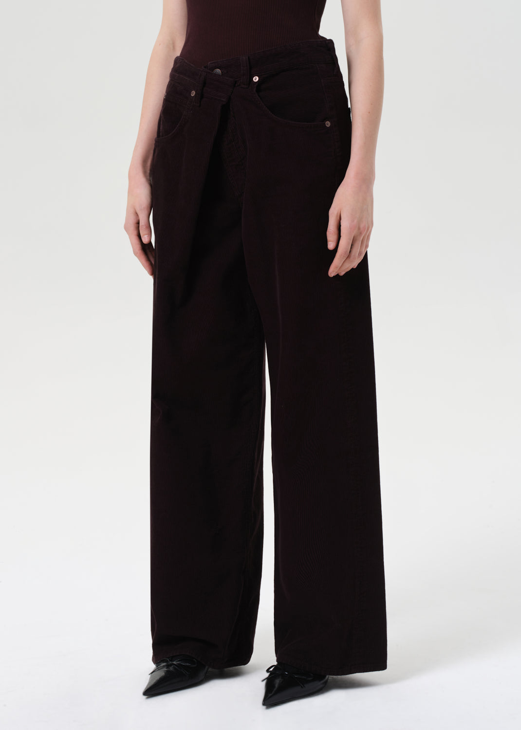 Person wearing black wide-leg pants on a white background