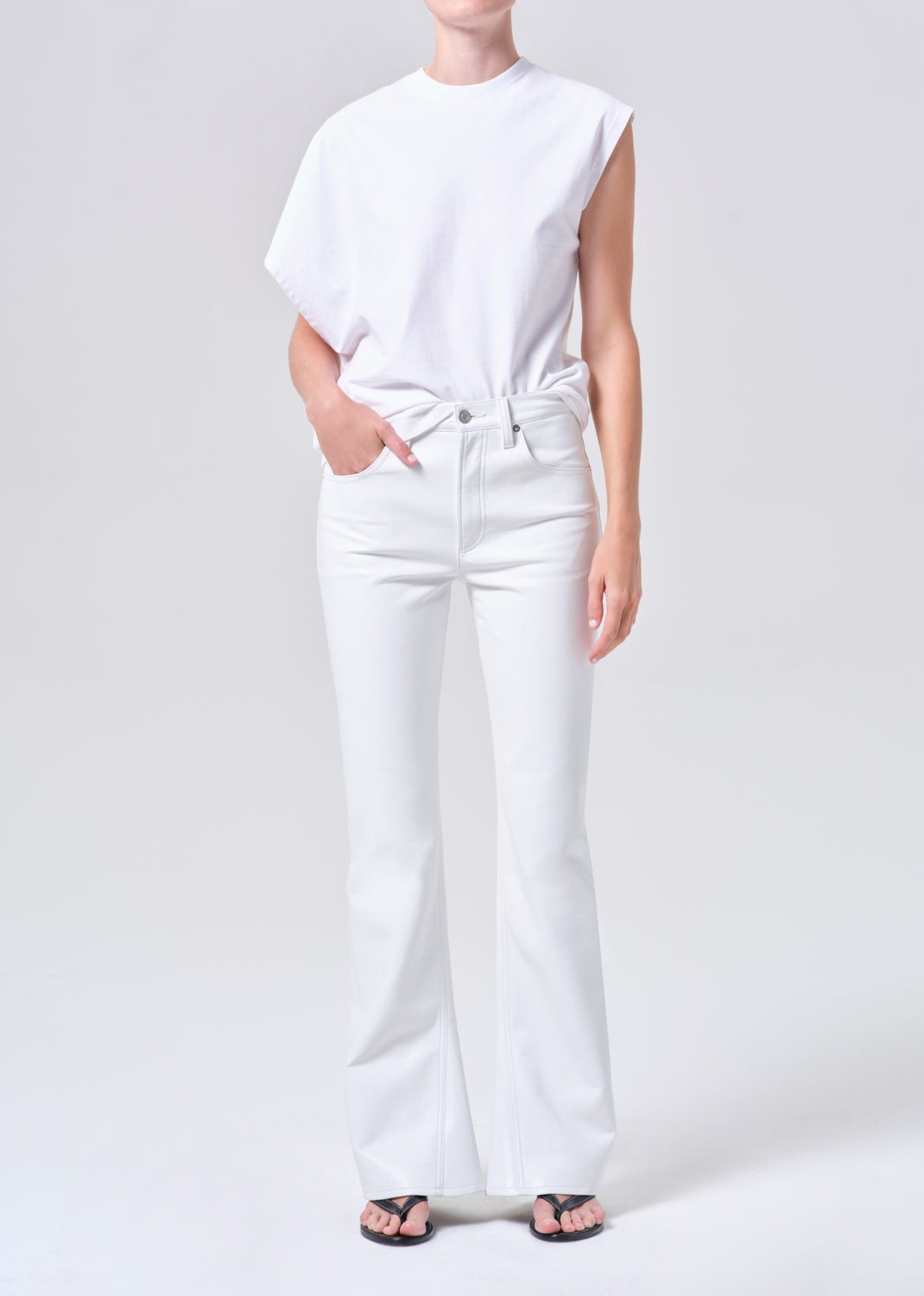 Person wearing a white t-shirt and white pants on a plain background