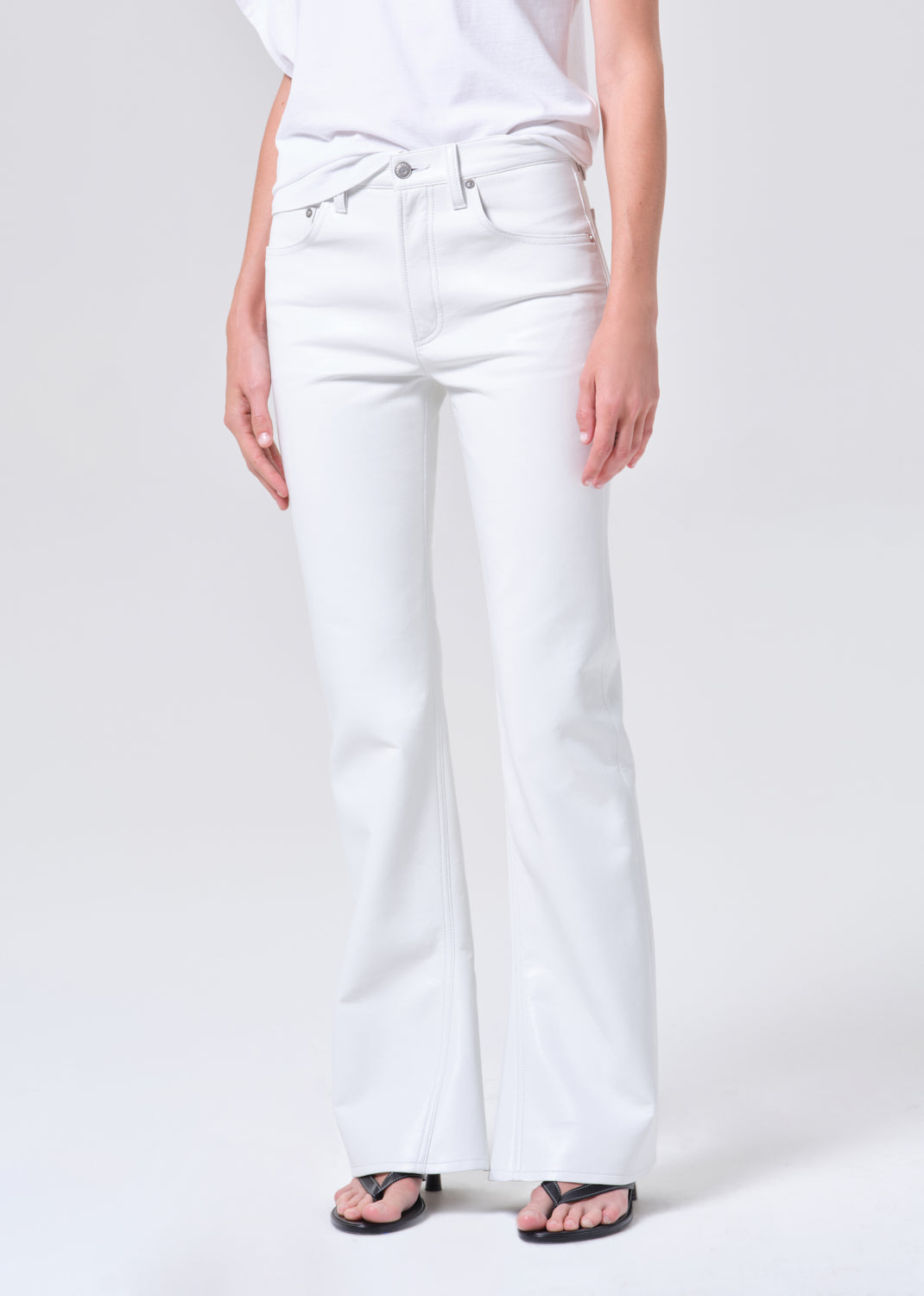 Person wearing white jeans on a plain background