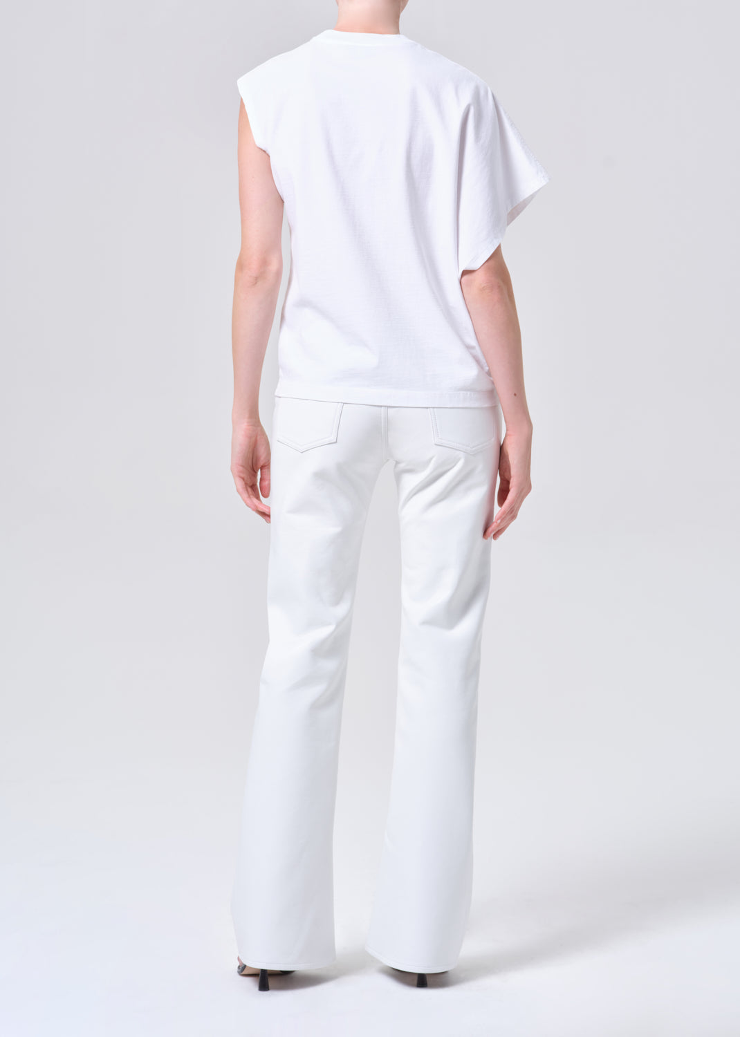 Person wearing a white sleeveless top and pants on a white background