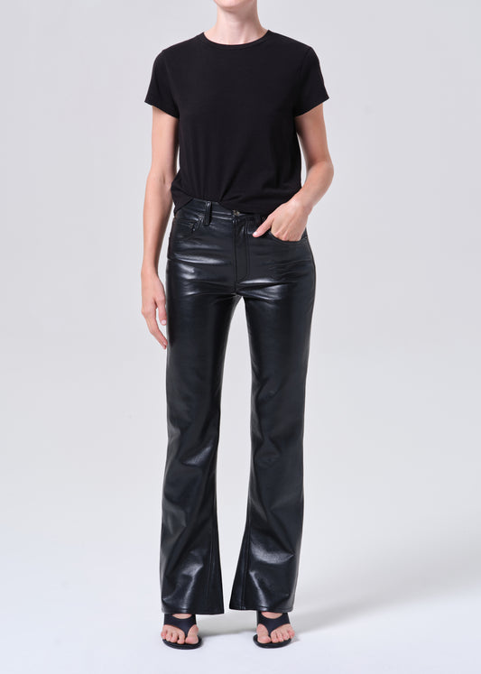 Person wearing black leather pants and a black t-shirt on a white background
