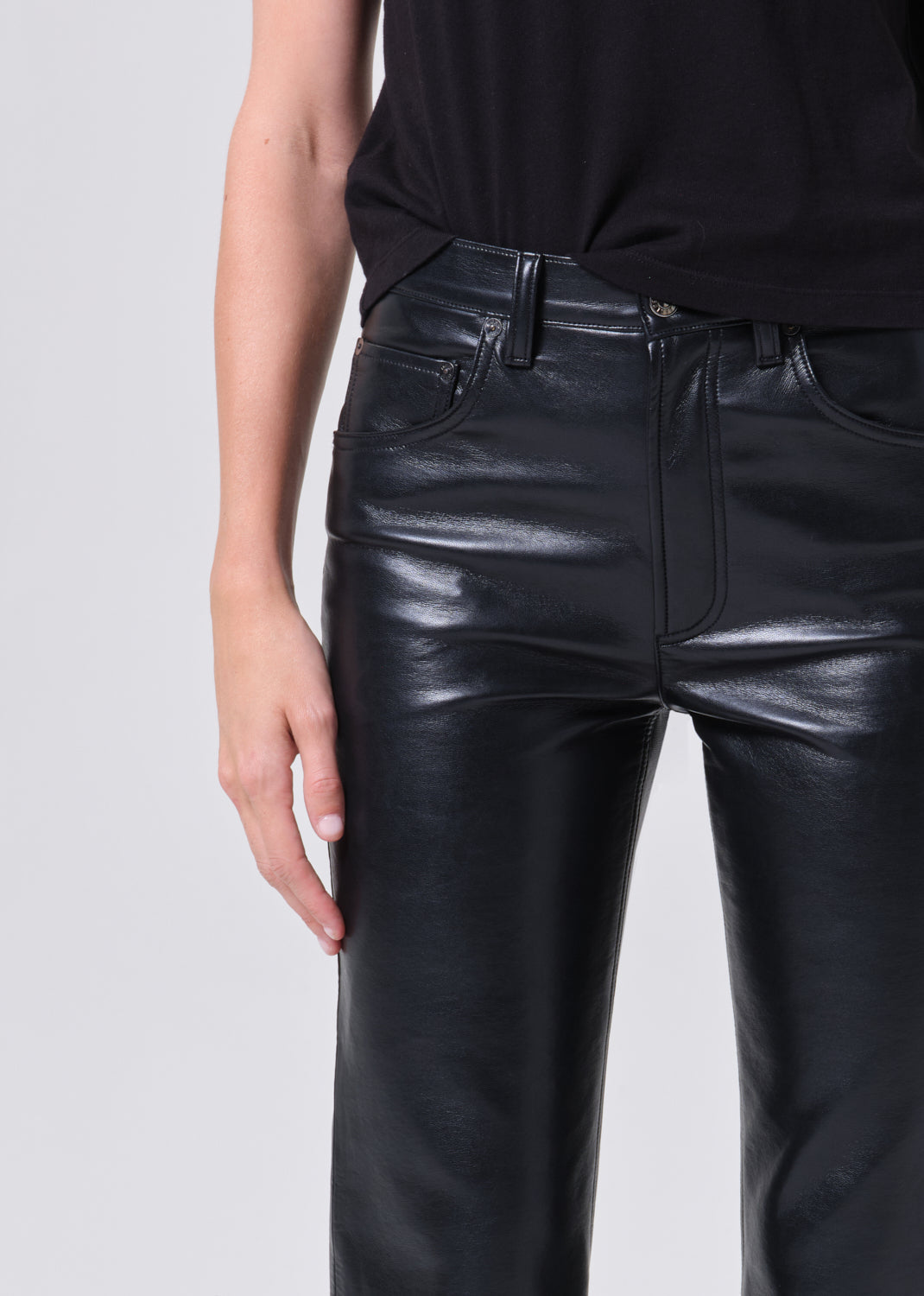 Black leather pants worn by a person on a light gray background