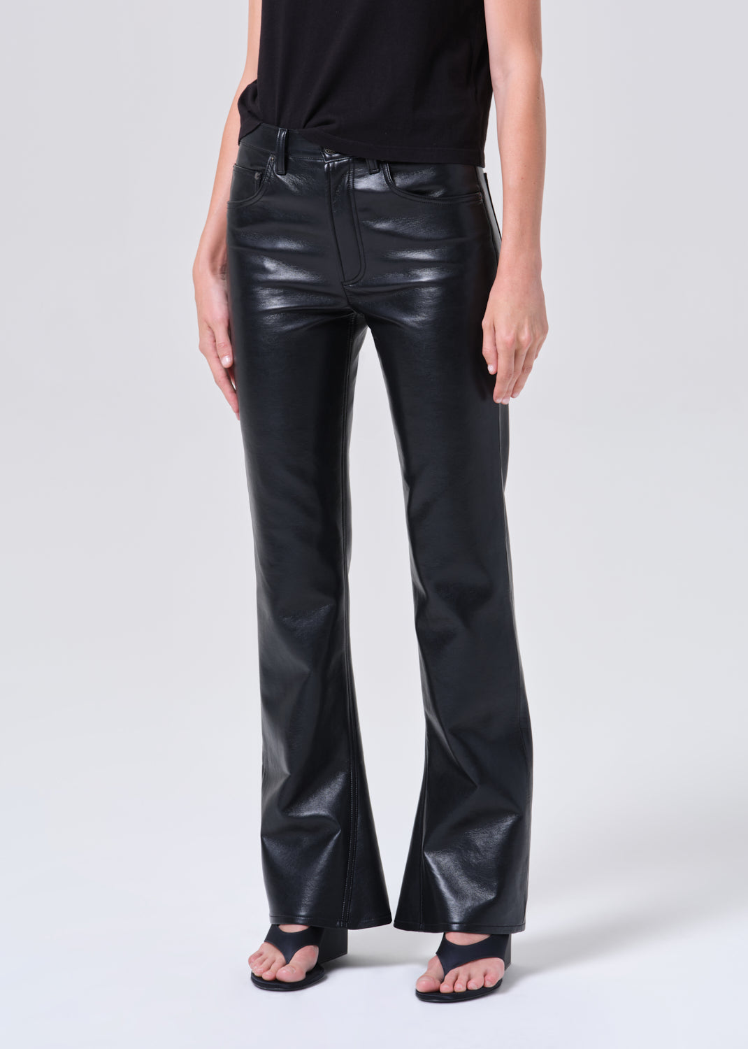 Person wearing black leather pants on a white background