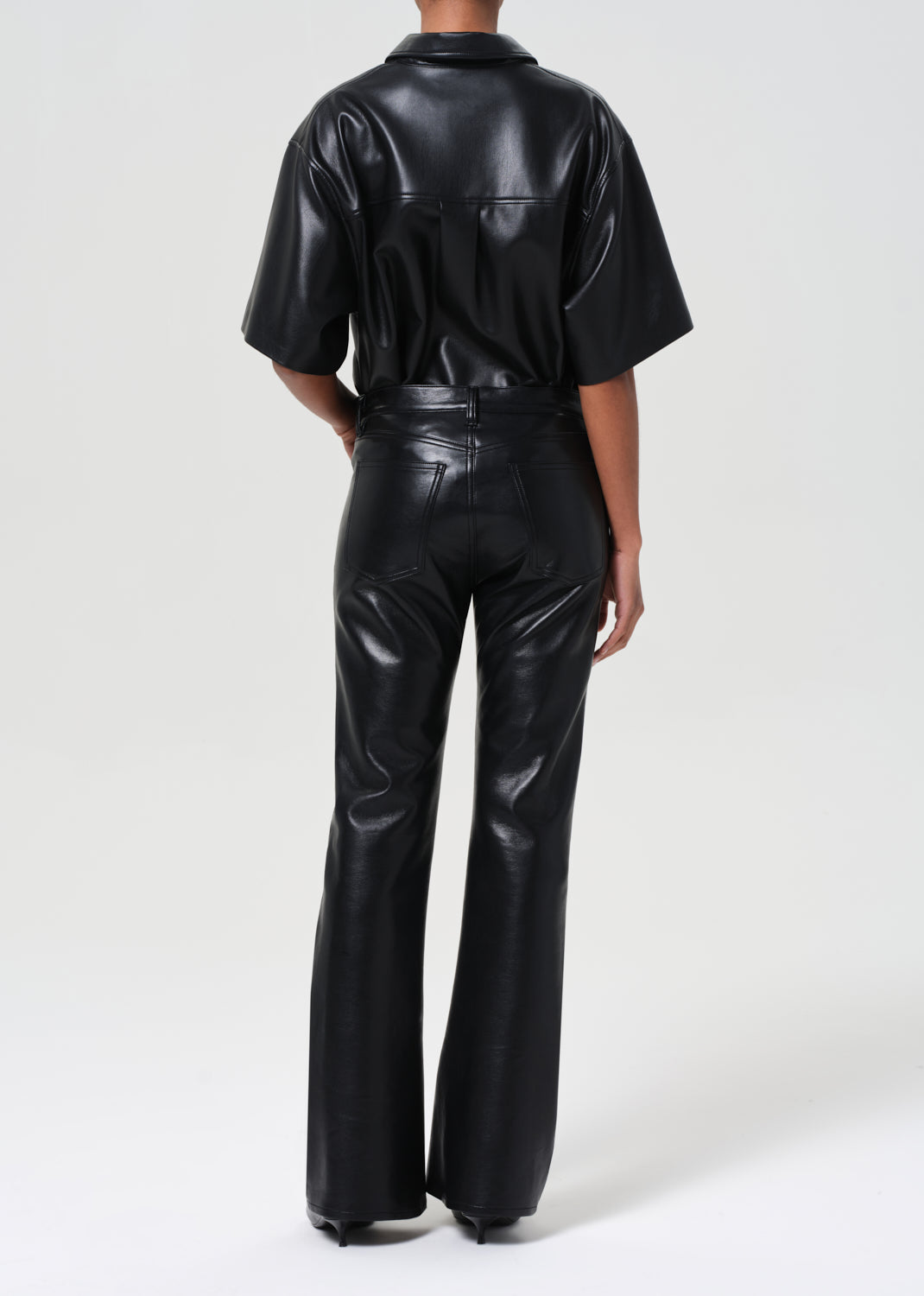 Person wearing a black leather outfit on a white background
