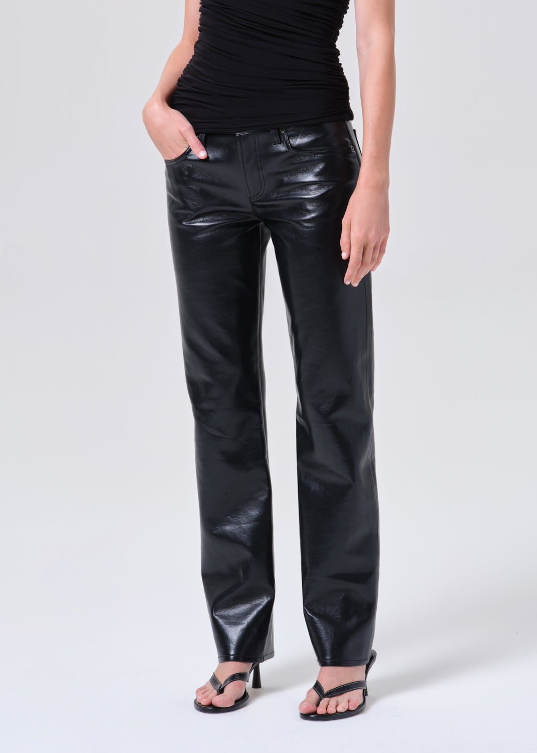 Person wearing black leather pants on a white background