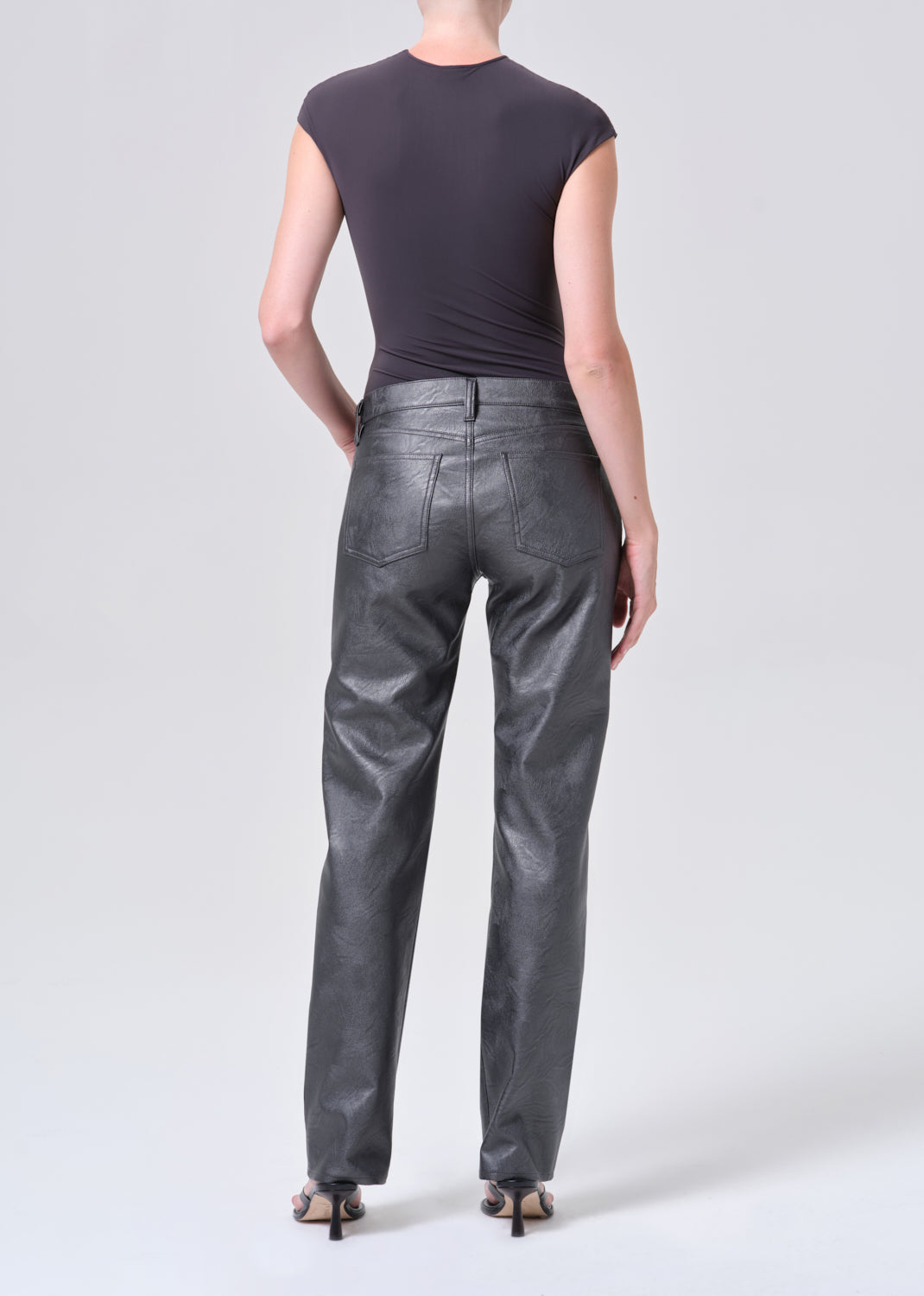 Person wearing black leather pants on a white background