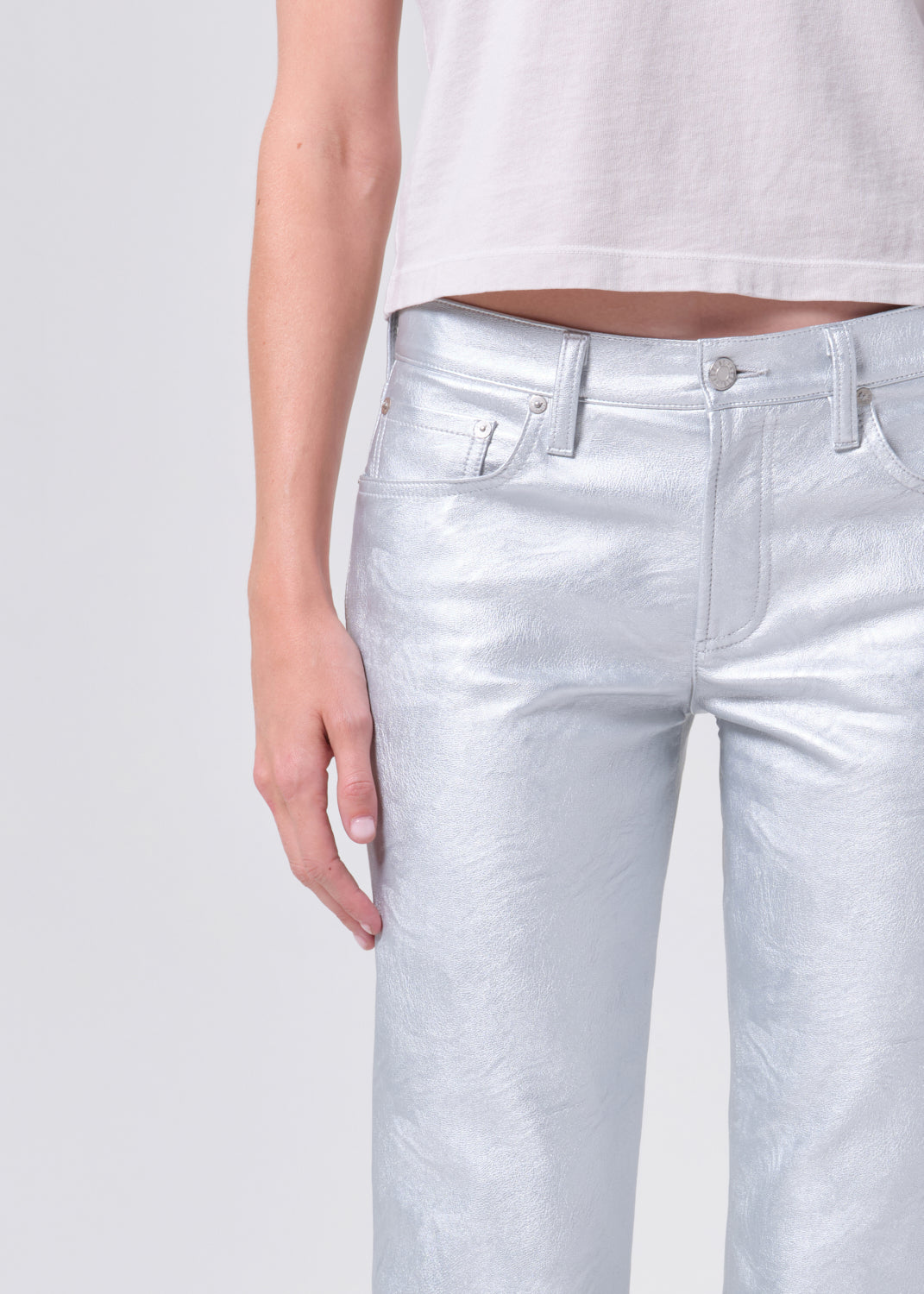 Silver pants worn by a person on a plain background