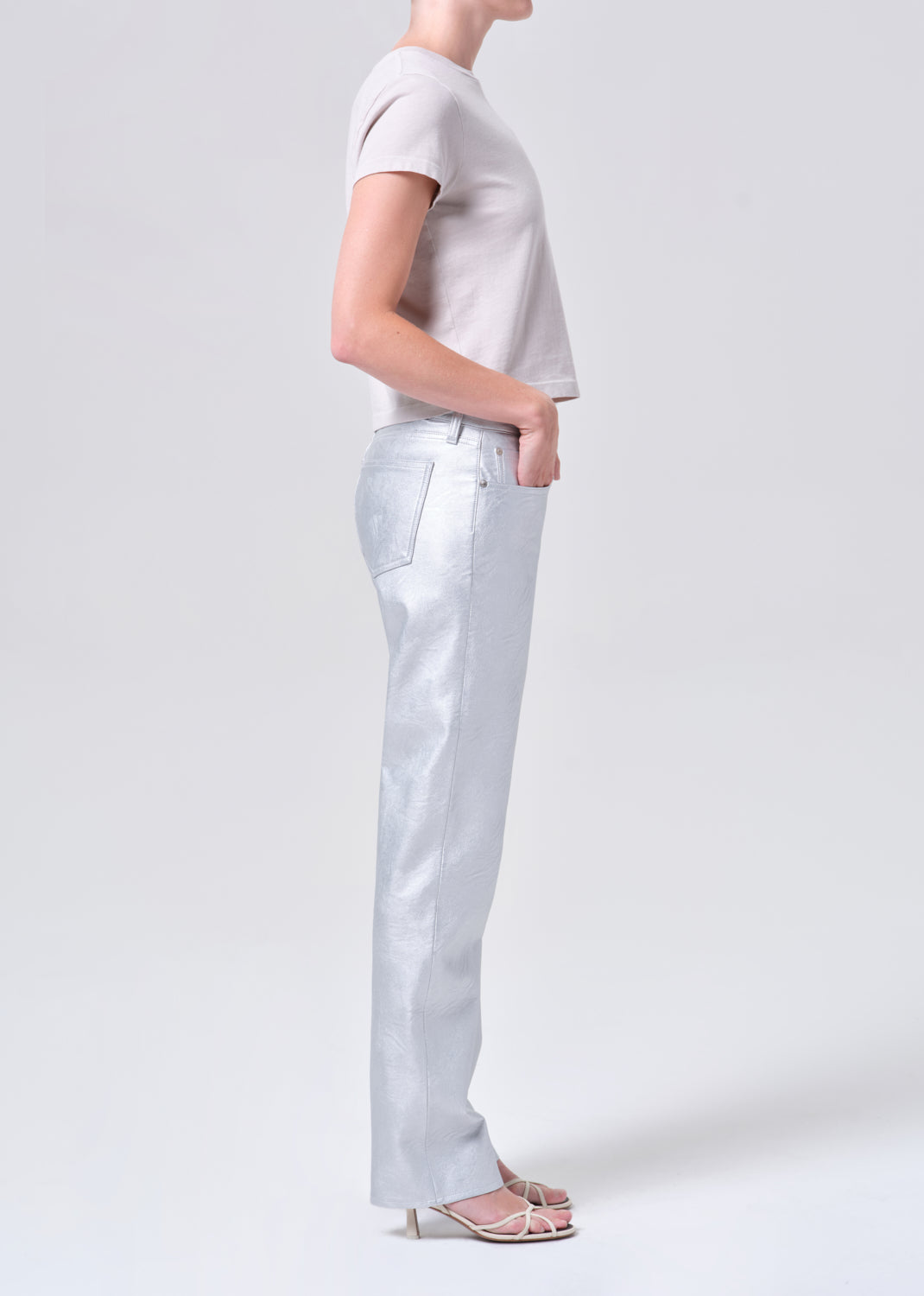 Person wearing a light gray t-shirt and white pants on a plain background