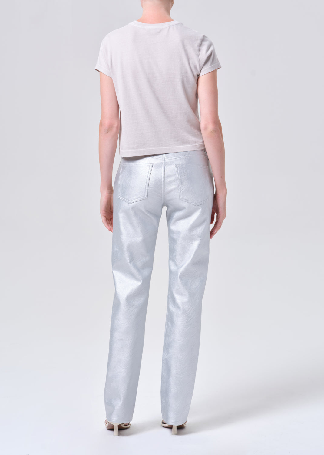 Person wearing a light gray t-shirt and pants on a white background