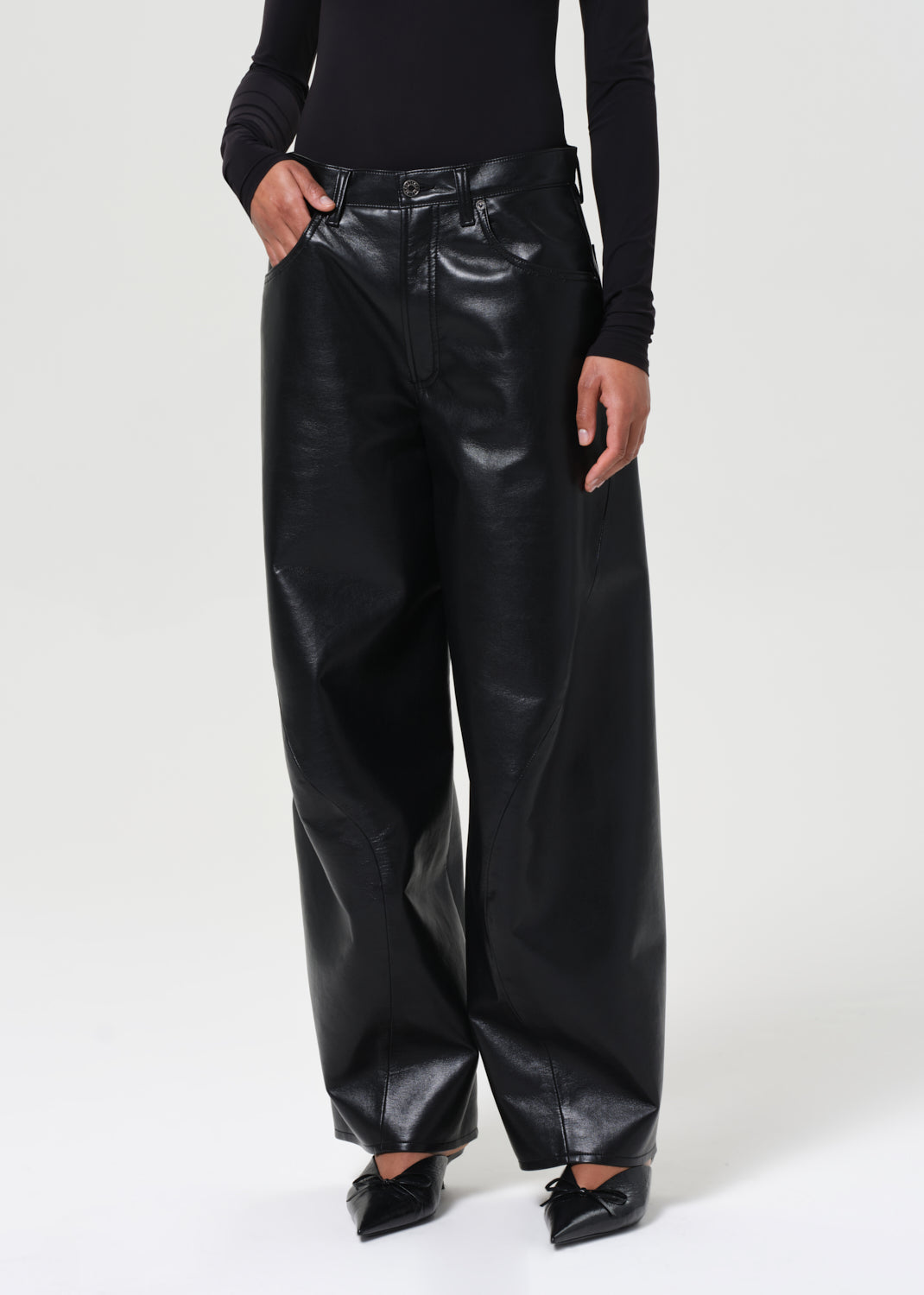 Person wearing black leather pants on a white background