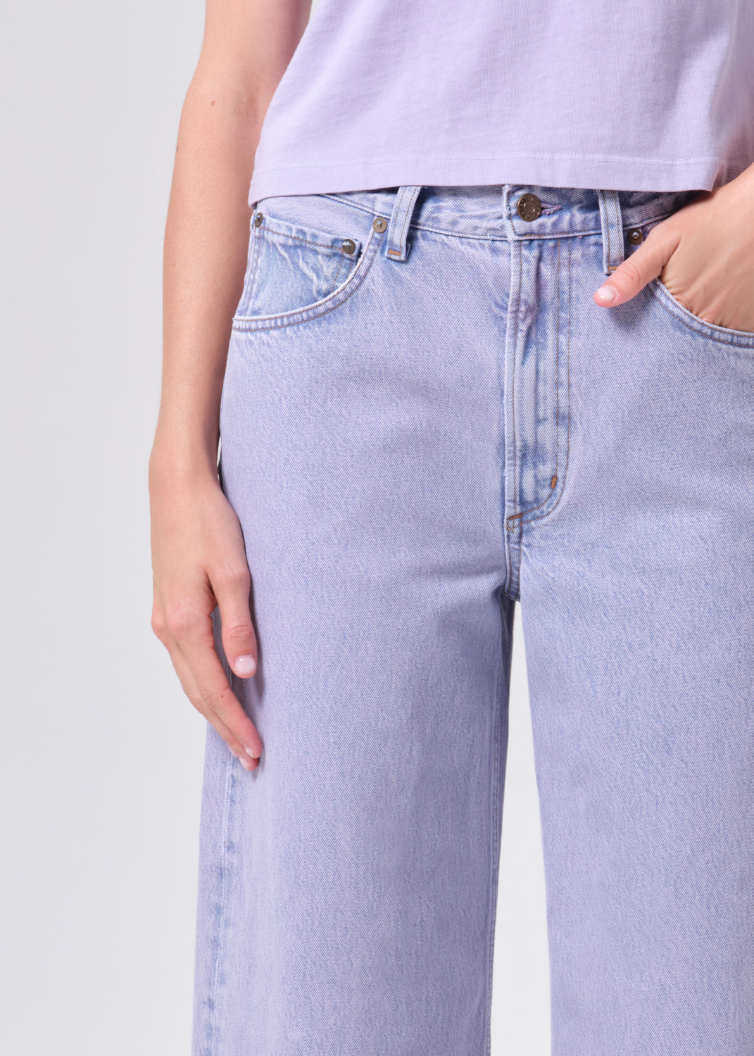 Light blue jeans worn by a person on a light gray background