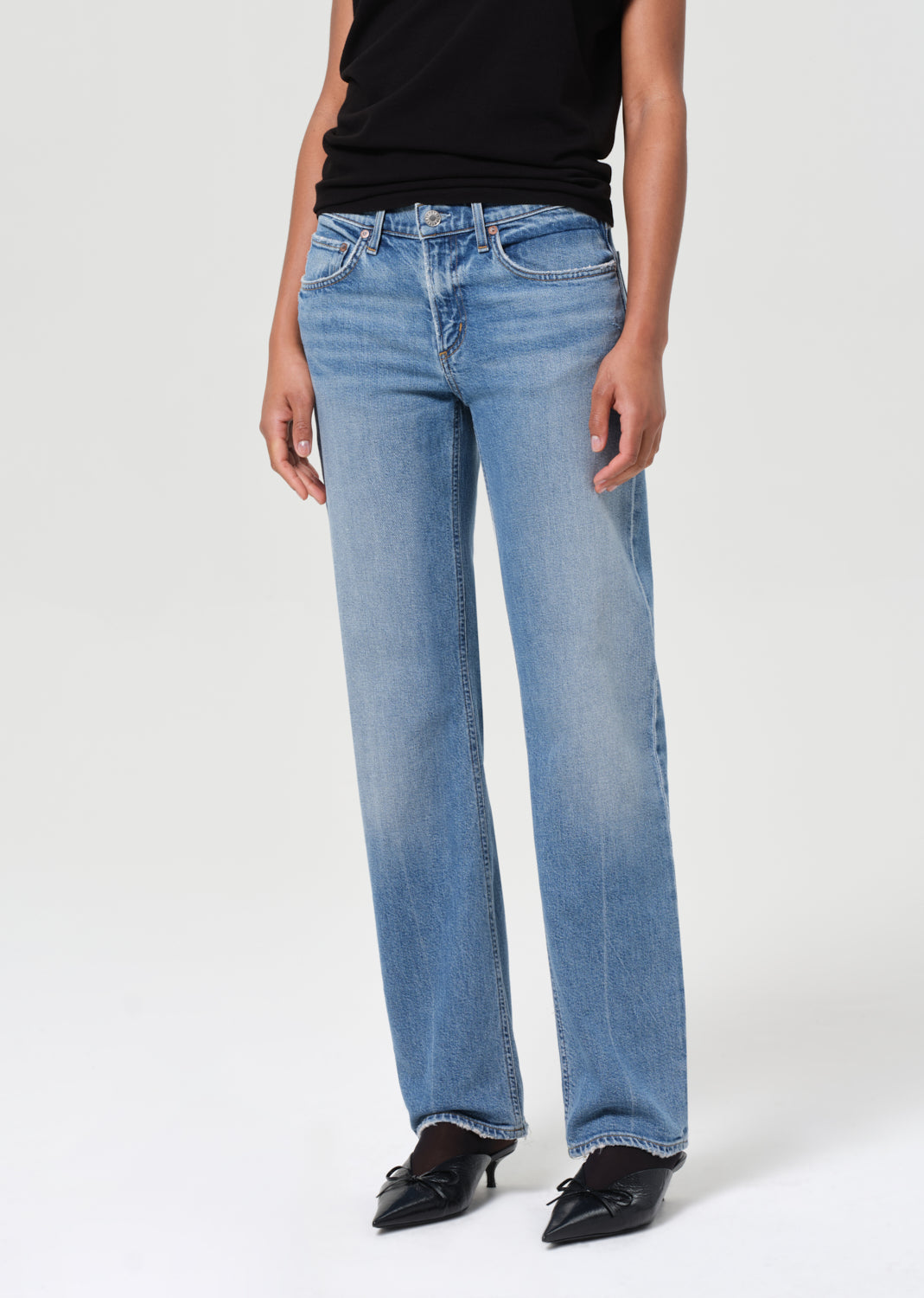 Person wearing light blue jeans on a white background