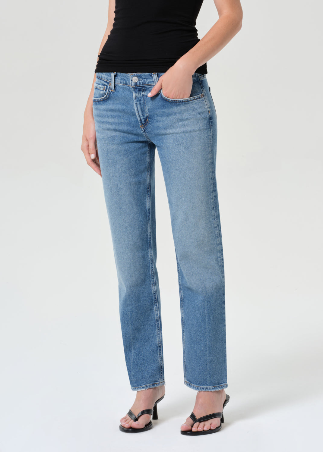 Person wearing light blue jeans on a white background