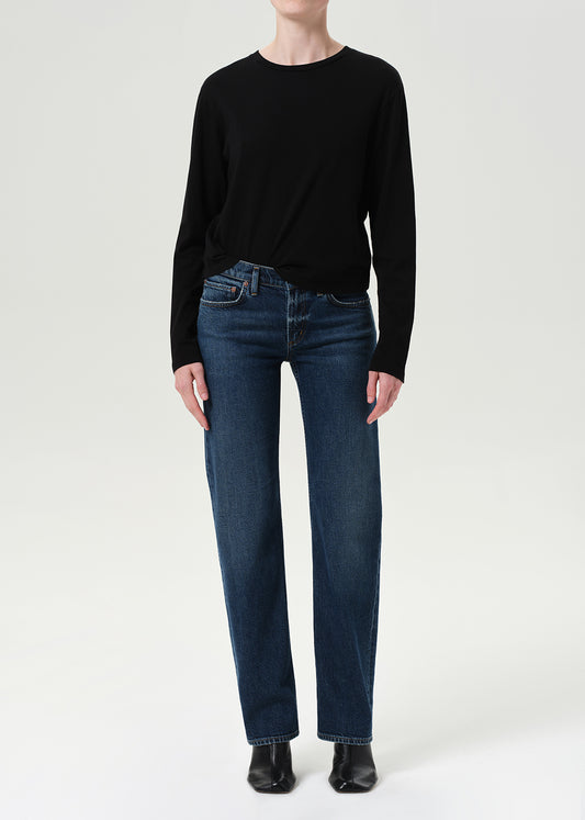 Person wearing a black sweater and blue jeans on a white background