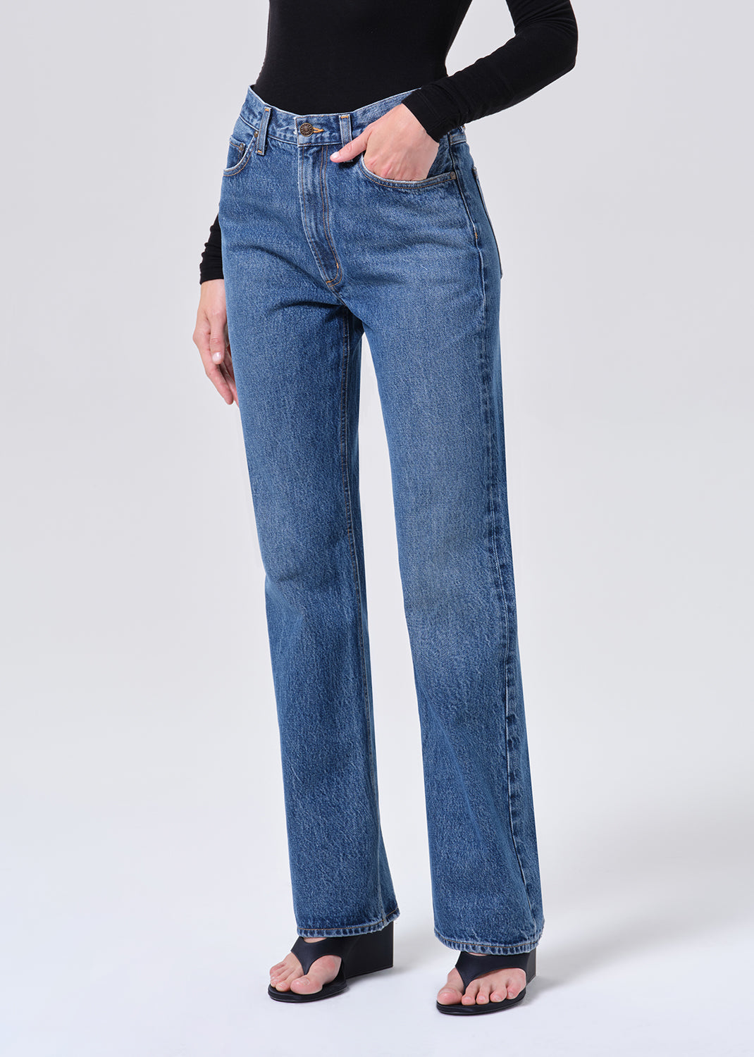 Person wearing blue jeans on a white background