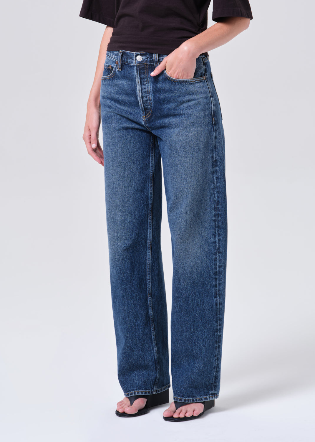 Person wearing blue jeans on a white background