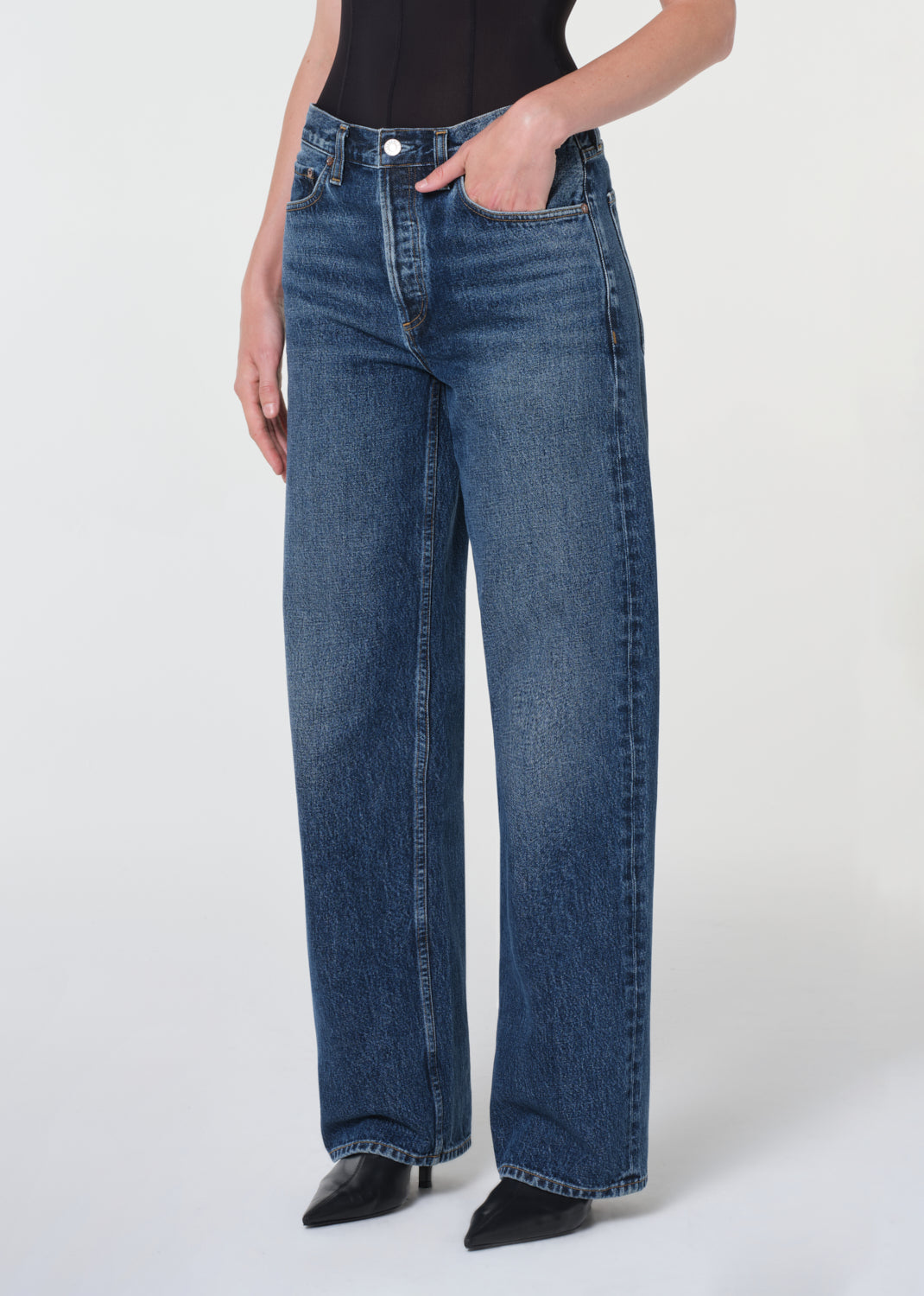Person wearing blue jeans on a white background