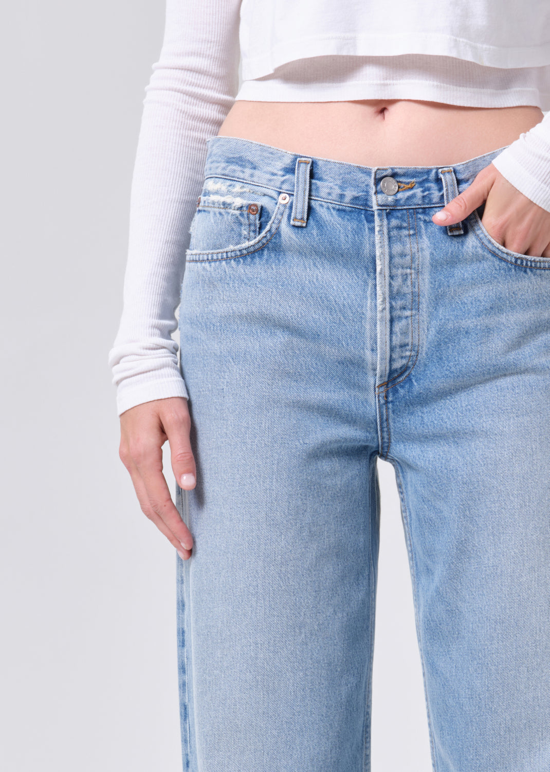 Light blue jeans worn by a person on a plain background