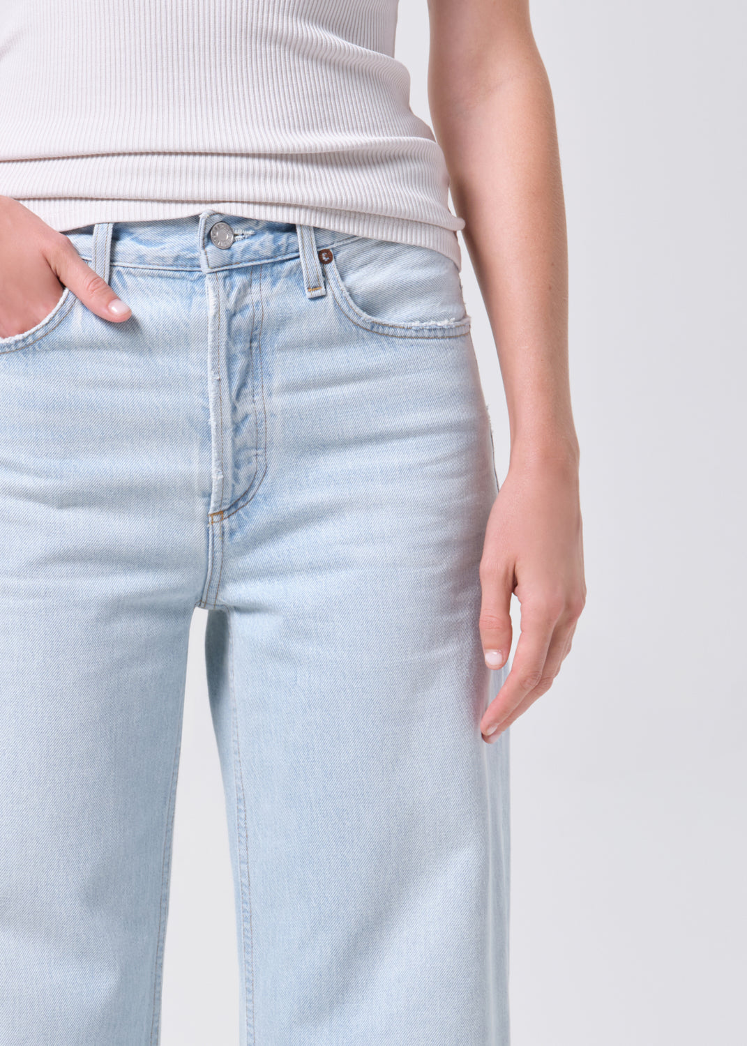 Light blue jeans worn by a person on a plain background