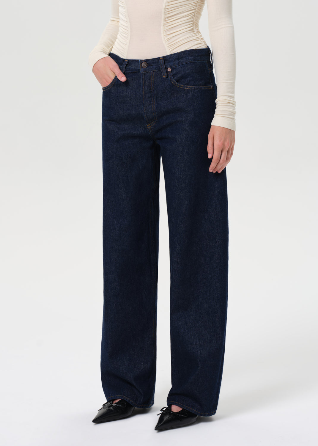 Person wearing dark blue jeans on a white background