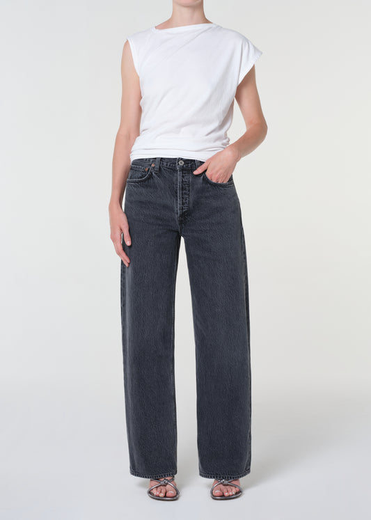 Person wearing a white t-shirt and dark blue jeans on a white background