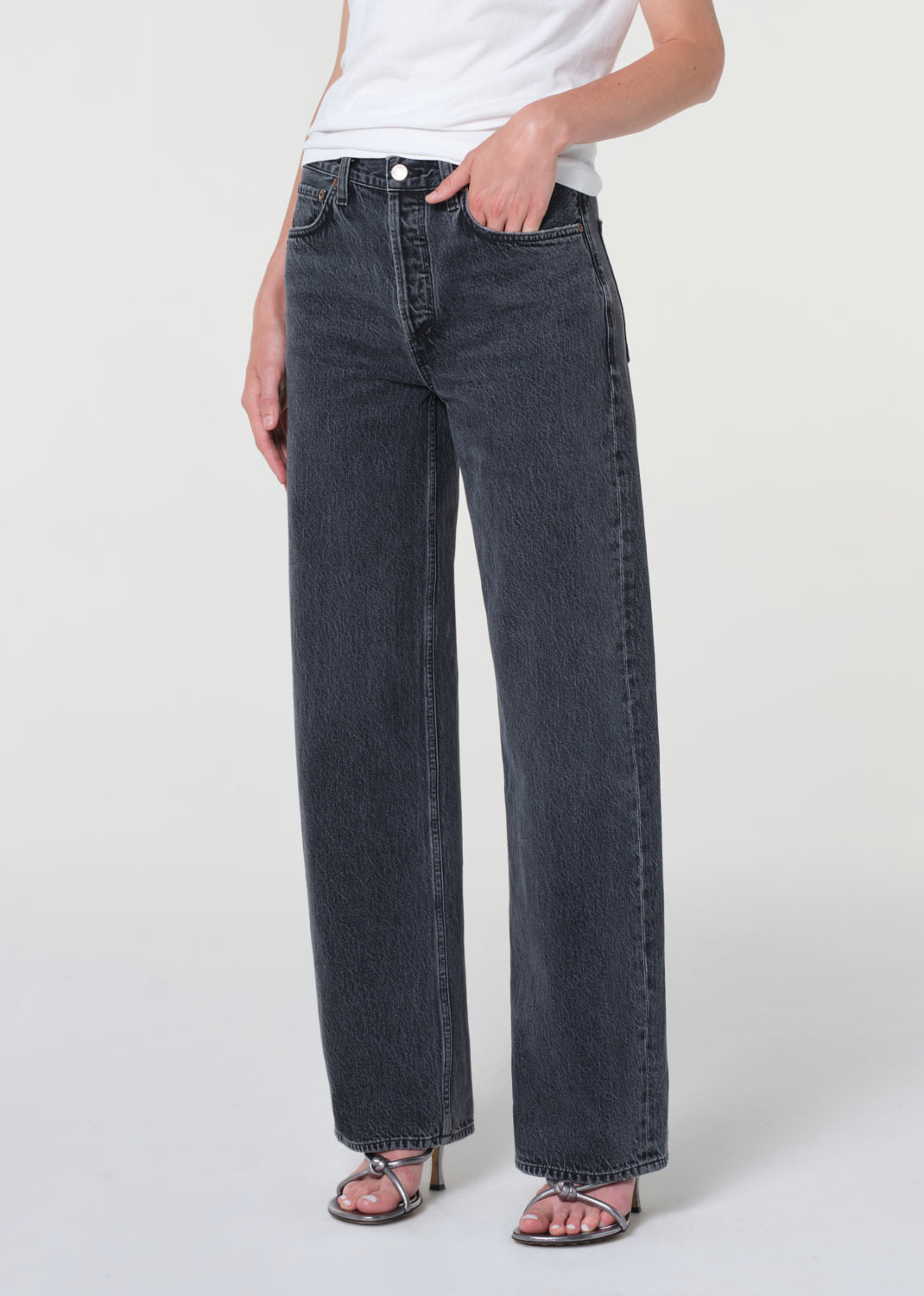 Person wearing black jeans and a white shirt on a white background