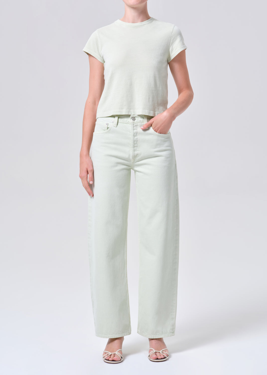 Person wearing a white t-shirt and pants on a plain background