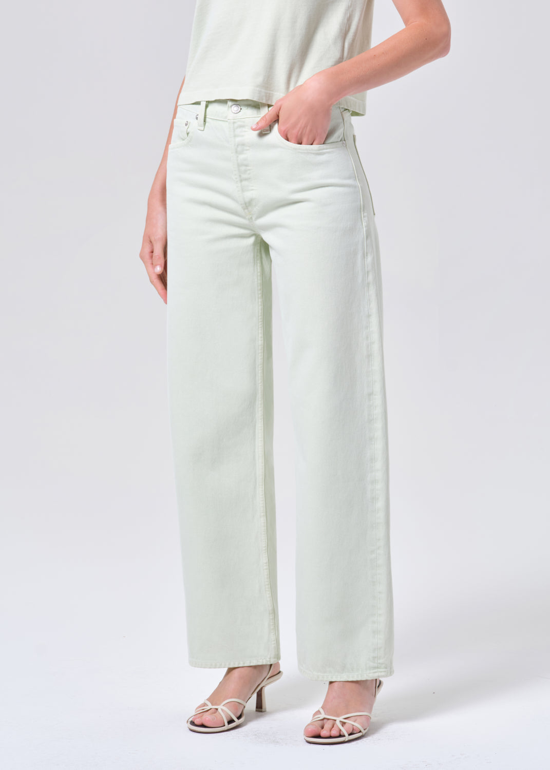 Light-colored wide-leg jeans worn by a person on a white background