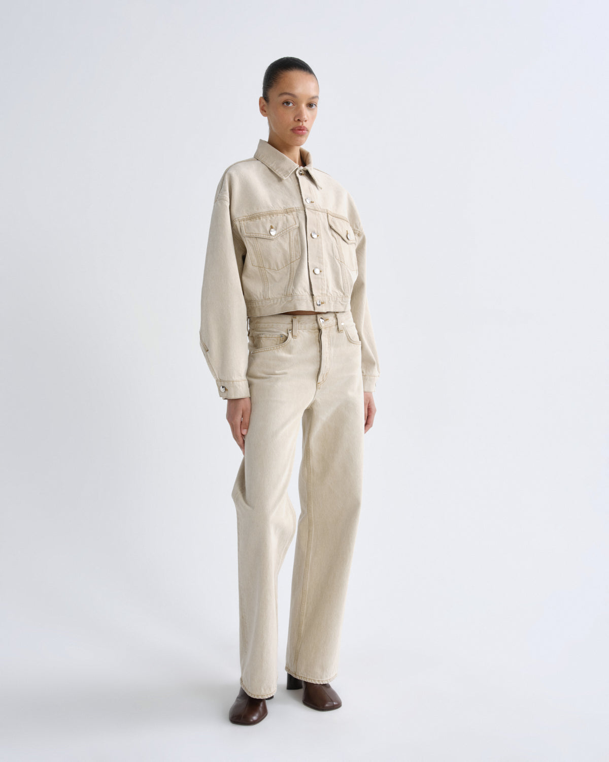 Person wearing a beige outfit on a white background