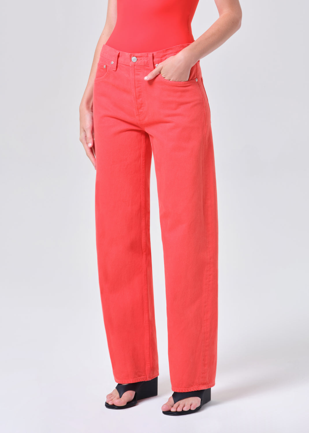 Person wearing bright red pants on a white background