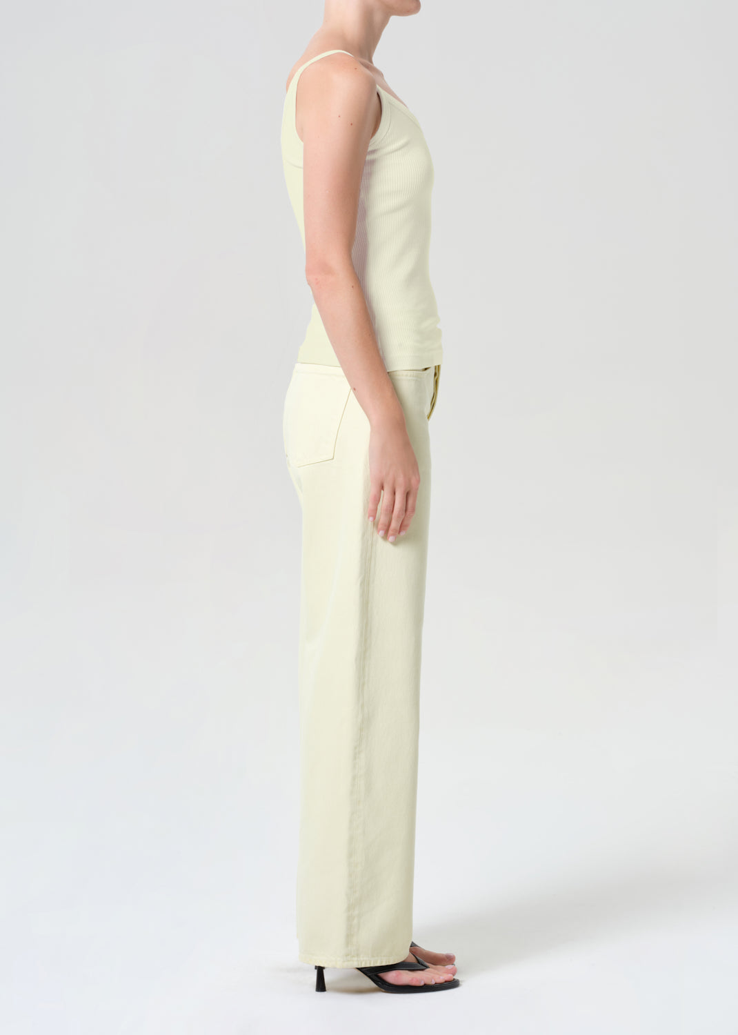 Person wearing a light green jumpsuit on a white background