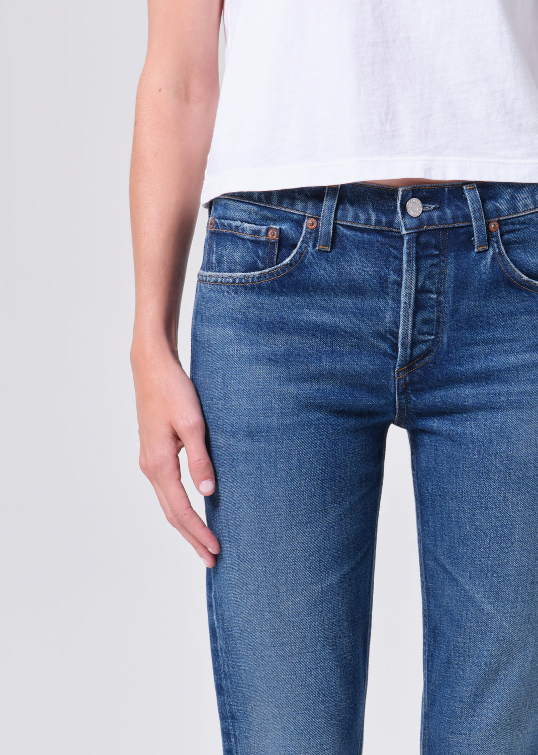 Blue jeans worn by a person on a light gray background