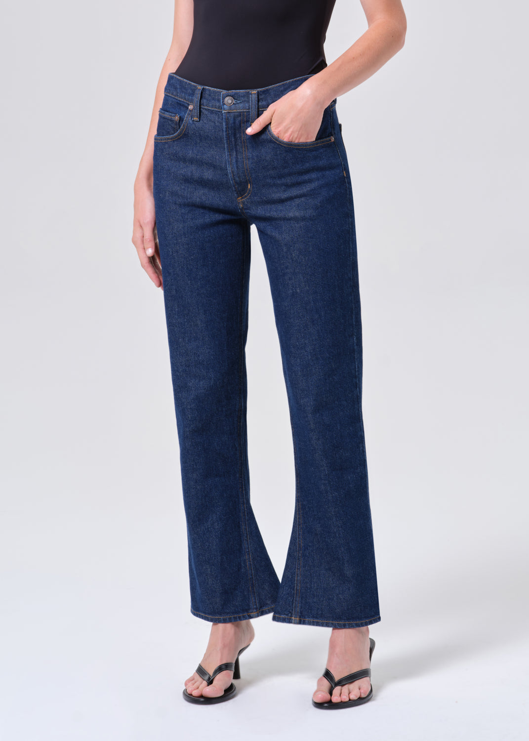 Person wearing dark blue jeans on a white background