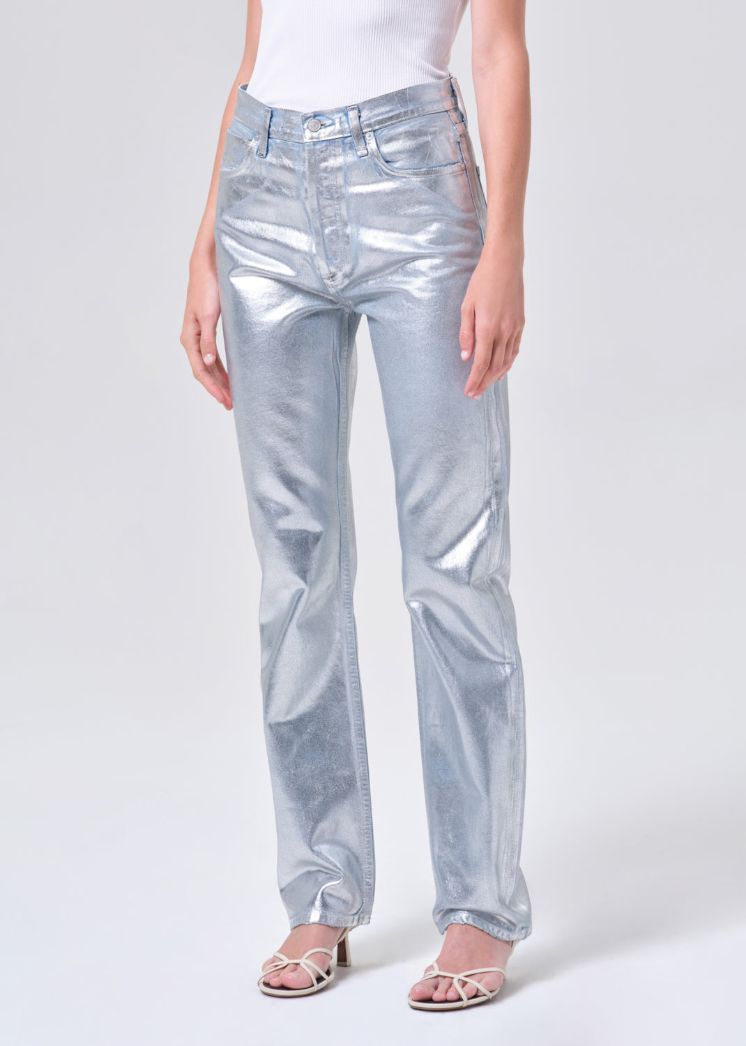 Person wearing shiny silver pants on a white background