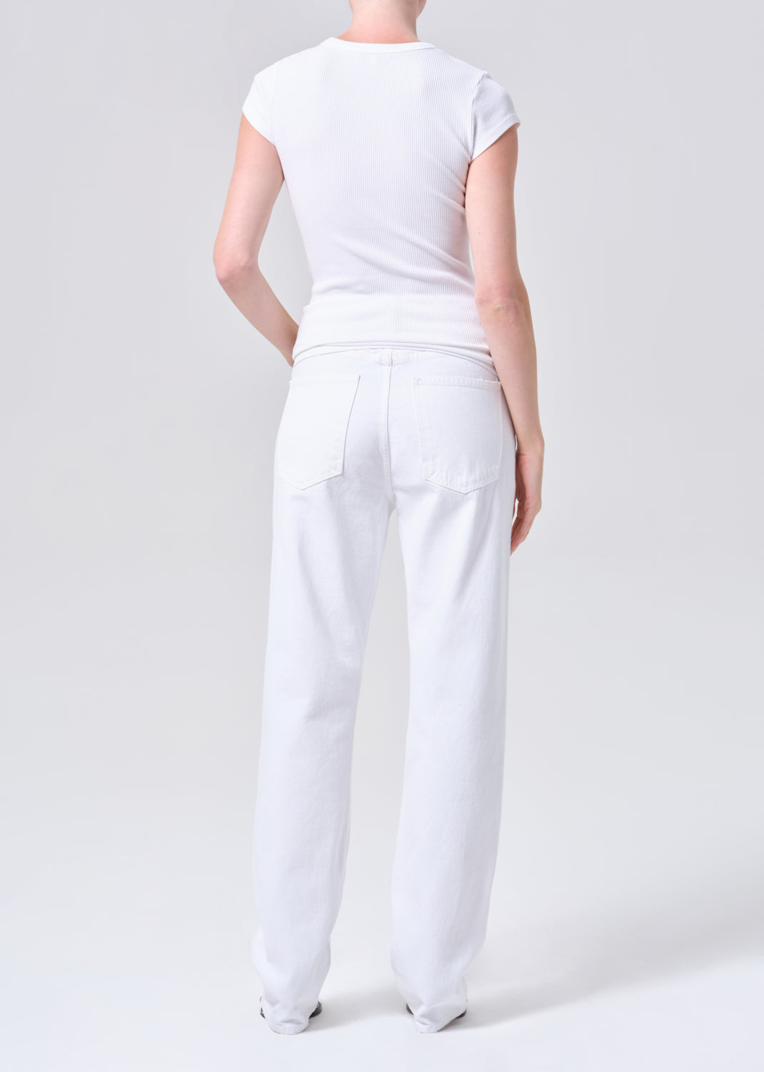 Person wearing a white outfit on a plain background